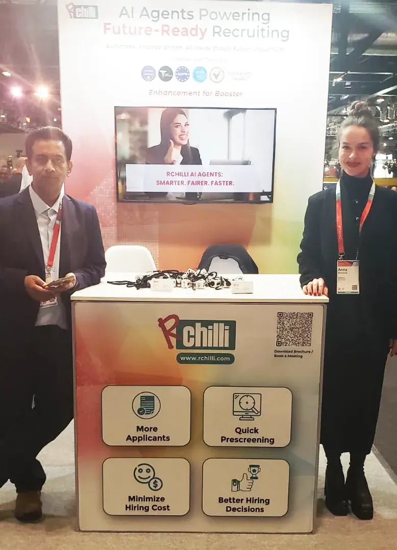 Two RChilli team members at the RChilli booth display wall